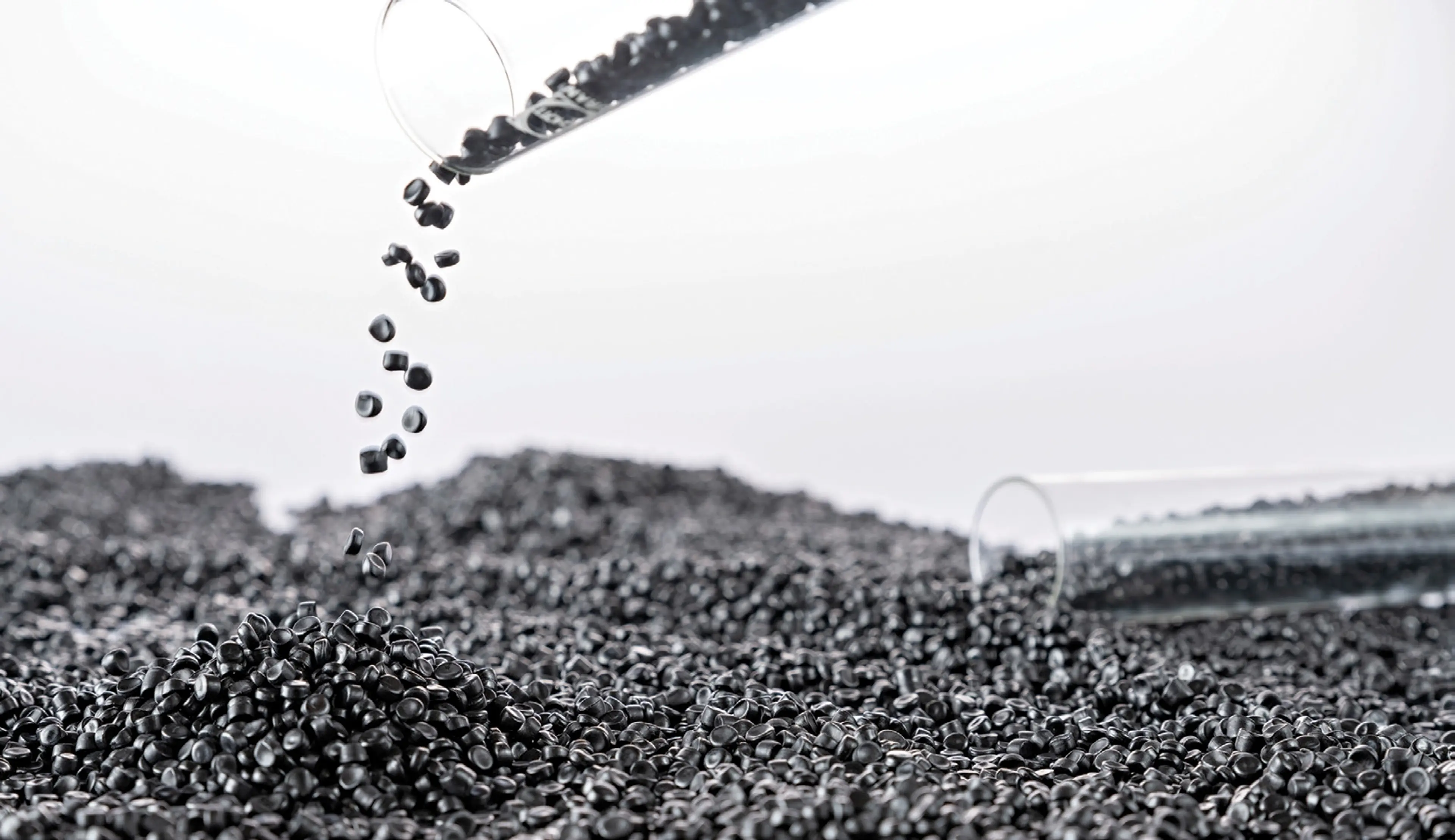 Black plastic pellets on white background