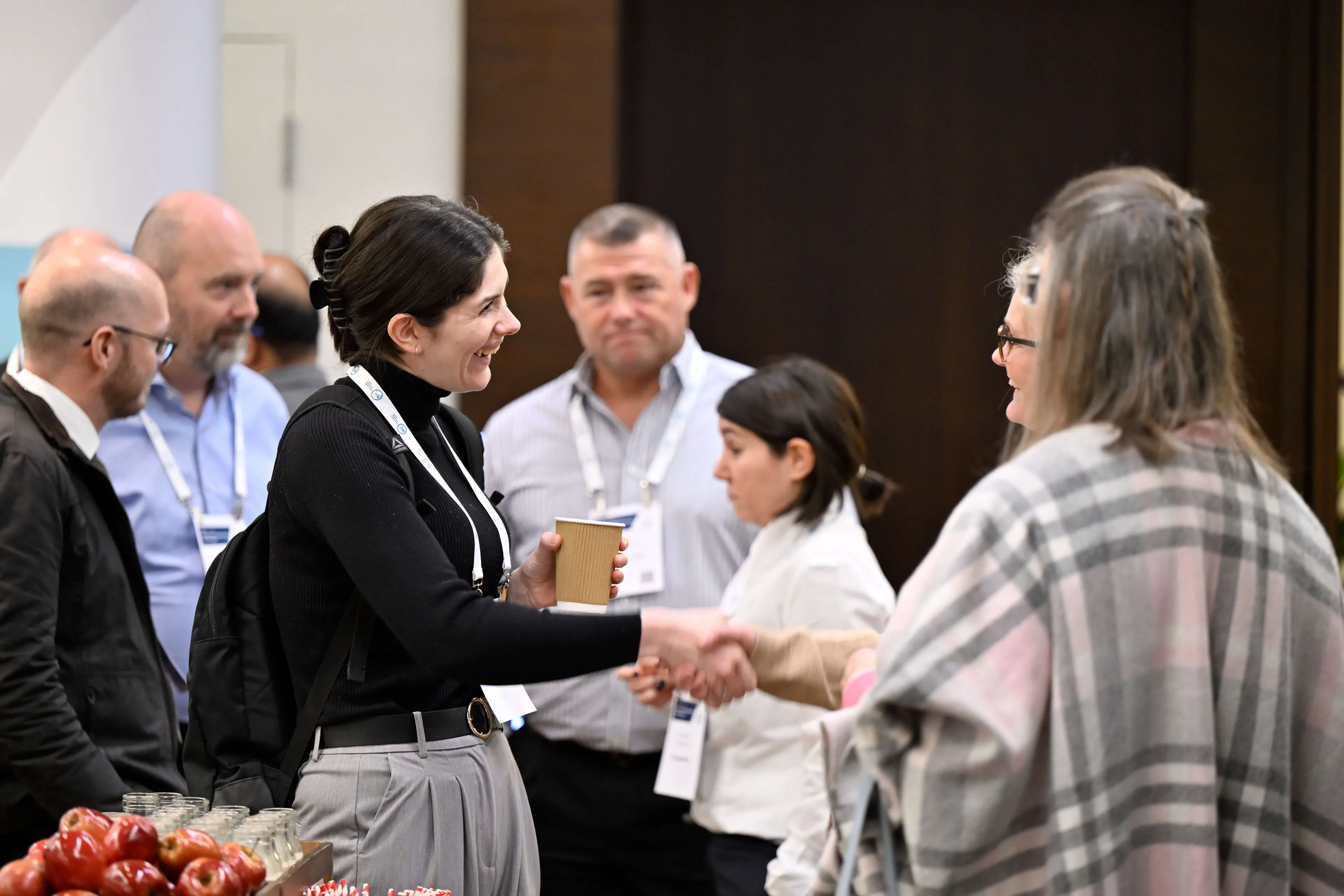 People shaking hands at an AMI conference networking session