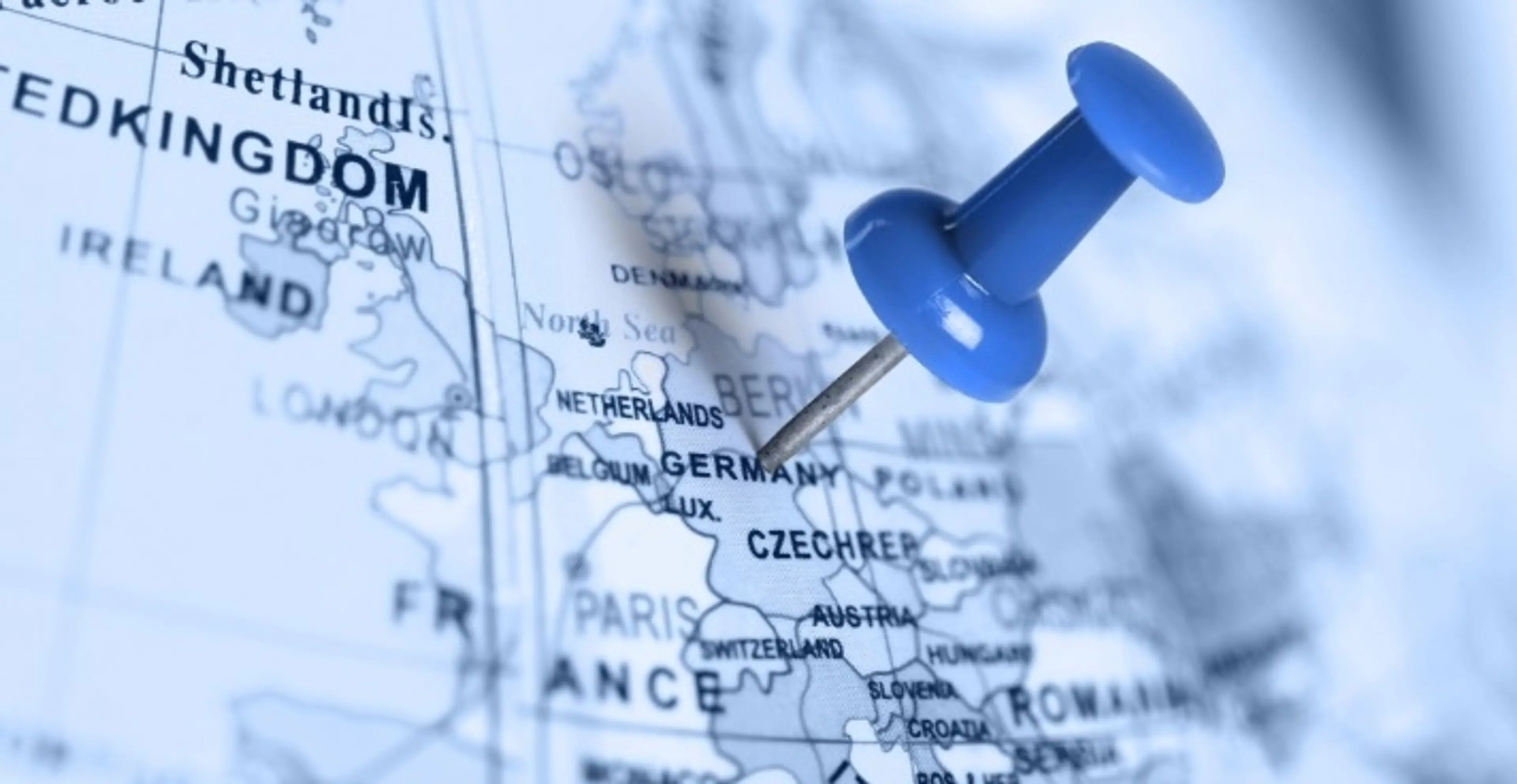 A blue map of Germany highlighted with blue map pin